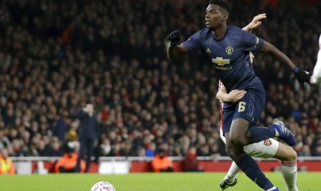 Pemain Manchester United Paul Pogba (kiri) beradu bola dengan pemain Arsenal Granit Xhaka dalam Piala FA di Stadium Emirates, Sabtu (16/1) dini hari.