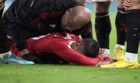  Pemain Manchester United Raphael Varane terbaring terluka di tanah saat pertandingan sepak bola Liga Premier Inggris antara Manchester United dan Chelsea di Stadion Stamford Bridge di London, Sabtu, 22 Oktober 2022.