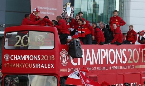 Pemain Manchester United, staf dan Alex Fergusson berada di bus tingkat terbuka untuk dalam parade kemenangan di Manchester, setelah meraih gelar juara  ke-13 Liga Primer Inggris