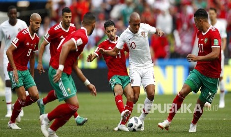 Pemain Maroko mencoba untuk menghentikan pemain Portugal Joao Mario pada  pertandingan grup B Piala Dunai antara Portugal dan Maroko  di Stadion Luzhniki di Moskow, Rusia,  Rabu (20/6).