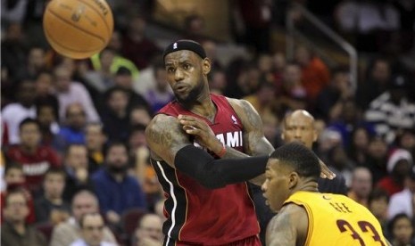 Pemain Miami Heat, LeBron James (kiri), melepaskan operan melewat defender Cleveland Cavaliers, Alonzo Gee, dalam laga NBA di Cleveland pada Rabu (20/3). 