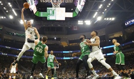 Pemain Milwaukee Bucks, Nikola Mirotic, melakukan lay up diadang pemain Boston Celtics pada play-off NBA di Milwaukee. 