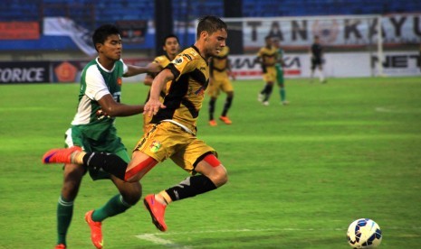 Pemain Mitra Kukar, Fetrick Dos Santos (kanan) berebut bola dengan pemain PS TNI Hendro Aprilianto saat babak delapan besar Piala Jenderal Sudirman di Stadion Manahan, Solo, Ahad (20/12). 