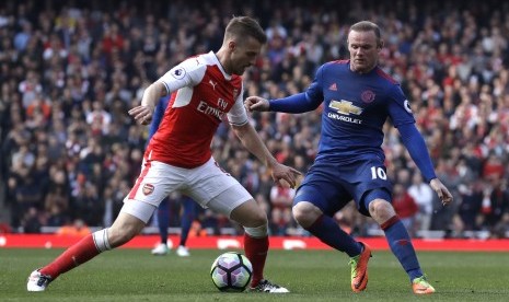 Pemain MU Wayne Rooney (kanan) berjibaku dengan pemain Arsenal Aaron Ramsey dalam pertandingan Liga Inggris di Emirates Stadium London, (7/5).