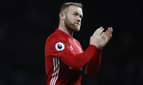 Pemain MU Wayney Rooney bertepuk tangan usai pertandingan melawan West Ham di Old Trafford, Senin (28/11).