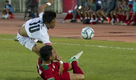 Pemain Myanmar Win Naing Tun Saling berebut bola dengan pemain Indonesia Nurhidayat Haji Haris dalam pertandingan sepak bola U-18 Sepak Bola ASEAN (AFF) U18 di stadion Thuwunna, Myanmar.