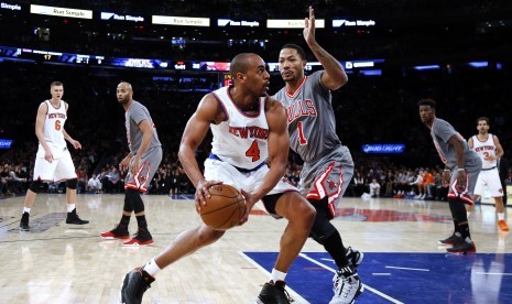 Pemain New York Knicks, Arron Afflalo (kiri), mencoba melewati hadangan pemain Chicago Bulls, Derrick Rose, dalam laga NBA di New York, Amerika Serikat, Sabtu (19/12). 