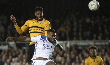 Pemain Newport County, Jamille Matt (kiri), berebut bola dalam duel udara dengan pemain Leicester City dalam laga Piala FA di Stadion Rodney Parade, Newport, Inggris, Ahad (6/1).