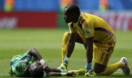 Pemain Nigeria, Vincent Enyeama (kanan), memeriksa   rekannya, Ogenyi Onazi, yang tergeletak setelah beradu   fisik dengan pemain Prancis di laga babak 16 besar Piala   Dunia 2014 di Stadion Nasional, Brasilia, Senin (30/6).   