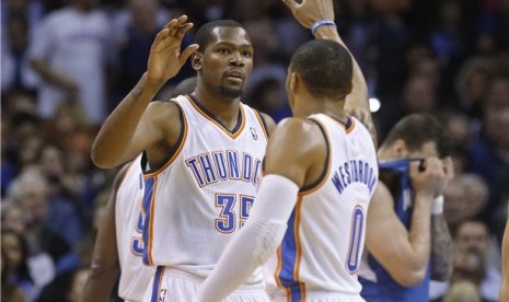 Pemain Oklahoma City Thunder, forward Kevin Durant (kiri) and guard Russell Westbrook (kanan), melakukan selebrasi 'high five' di kuarter pertama laga NBA lawan Minnesota Timberwolves di Oklahoma City pada Ahad (1/12). 