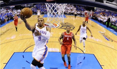 Pemain Oklahoma City Thunder, Russell Westbrook (kiri), menjaringkan bola dalam laga NBA. 