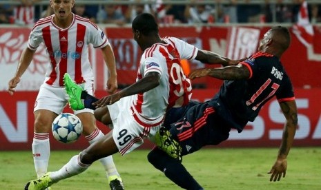 Pemain Olympiakos berjibaku dengan Ideye Brown berusaha menghambat upaya bek Bayern Muenchen Jerome Boateng