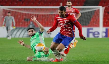 Pemain Omonia Ioannis Kousoulos berebut bola dengan pemain Granada Luis Suarez di pertandingan Grup E Liga Europa di Nuevo Estadio de Los Carmenes, Granada, Spanyol. (26/11/2020)