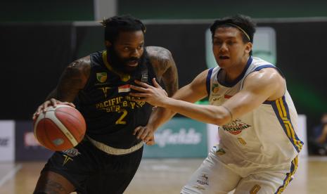 Pemain Pacific Caesar Surabaya Akeem Garfield Ellis (kiri) mencoba melewati hadangan Pemain Satria Muda Pertamina Jakarta Juan Laurent Kokodiputra dalam laga IBL di Jakarta, Jumat (18/3/2022). Satria Muda berhasil menang dengan skor 82-49. 