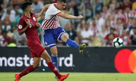  Pemain Paraguay Oscar Cardozo menendang bola dijaga pemain Qatar Tarek Salman pada laga Grup B Copa America 2019 di Stadion Maracana, Rio de Janeiro, Brasil, Senin (17/6) dini hari WIB.