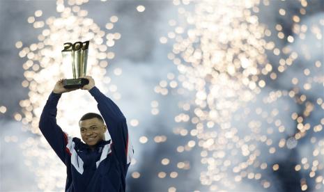 Pemain Paris Saint Germain Kylian Mbappe mengangkat trofi yang diberikan klubnya setelah ia menjadi pencetak gol terbanyak sepanjang PSG dengan 201 gol selepas pertandingan sepak bola Ligue 1 Prancis antara PSG dan FC Nantes di stadion Parc des Princes di Paris, Prancis, Ahad (5/3/2023).