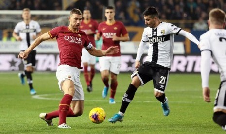 Pemain Parma Matteo Scozzarella (kanan) berebut bola dengan pemain Roma  Edin Dzeko dalam pertandingan pekan ke-12 Serie A Italia di Stadion Ennio Tardini, Ahad (10/11) malam WIB.