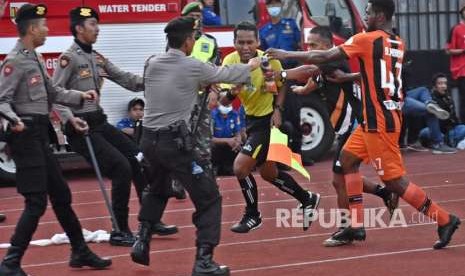 Pemain Perseru Serui Dony Harold Monim (kanan) mengejar asisten wasit Tri Wahyudi (ketiga kanan) untuk memprotes keras dalam pertandingan melawan PSIS Semarang saat pertandingan lanjutan Liga 1 Indonesia di Stadion Moch. Soebroto, Magelang, Jawa Tengah, Ahad (23/9).