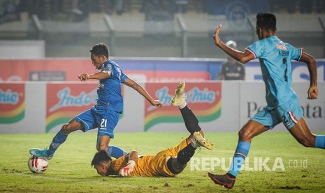 Pemain Persib Bandung Frets Butuan (kiri) melewati penjaga gawang Persela Lamongan Recky Rahayu pada pertandingan pekan pertama Liga 1 Indonesia di Stadion Si Jalak Harupat, Kabupaten Bandung, Jawa Barat, Minggu (1/3/2020). Pertandingan tersebut dimenangkan oleh Persib Bandung dengan skor 3-0. 