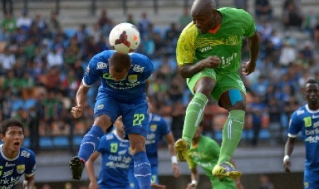 Pemain Persib Bandung, Supardi Nasir (kiri) duel udara dengan penggawa Persebaya Surabaya, Emmanuel Kenmogne.