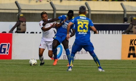 Pemain Persib berebut bola dengan pemain Madura United dalam pertandingan lanjutan Liga 1 Indonesia di Stadion Si Jalak Harupat, Bandung, Jabar, Ahad (23/6)