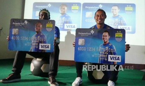 Pemain Persib Essien (kiri) dan Atep (kanan) memegang mock up kartu Permata Syariah Persib DebitPlus, di Graha Persib, Jalan Tamansari, Kota Bandung, Kamis (7/8).