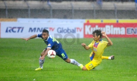    Pemain Persib Firman Utina (kiri) terjatuh saat berebut bola dengan Pemain Arema Malang Juan Revi(kanan) pada Laga Lanjutan Indonesia Super League di Stadion Si Jalak Harupat, Kabupaten Bandung, Ahad (13/4).  (foto: Septianjar Muharam)