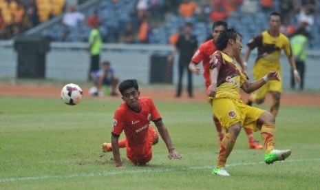 Pemain Persija Jakarta Agung Supriyanto (kiri) berjibaku dengan pemain Sriwijaya FC Asri Akbar (kanan).