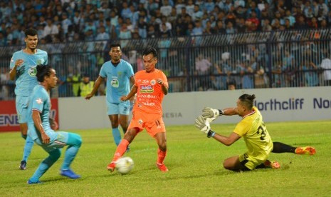 Pemain Persija Jakarta Novri Setiawan (kedua kanan) berusaha melewati pemain Persela Lamongan Samsul Arifin (kiri) dan penjaga gawang Dwi Kuswanto (kanan) dalam pertandingan Liga 1 2019 di Stadion Surajaya Lamongan, Jawa Timur, Sabtu (22/6).