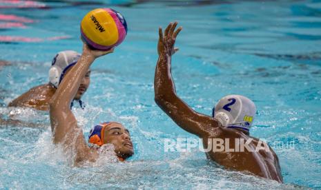 Pemain polo air DKI Jakarta Gyasi Kahlitijani (kiri) berusaha melempar bola dengan dihadang pemain polo air Jambi Endrianto Dwi Kurnia (kanan) pada pertandingan Polo Air putra PON Papua di Stadion Akuatik, Kampung Harapan, Kabupaten Jayapura, Papua, Kamis (30/9/2021). Tim polo air DKI Jakarta menang telak atas Jambi dengan skor akhir 26-4.