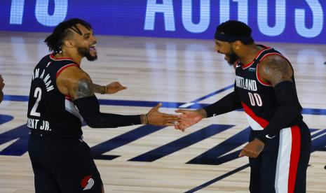 Pemain Portland Trail Blazers Carmelo Anthony (kanan) dan Gary Trent Jr. merayakan poin masuk saat melawan Memphis Grizzlies dalam laga play-in NBA, Ahad (16/8) WIB. Blazers mengalahkan Grizzlies dan lolos ke play-off.