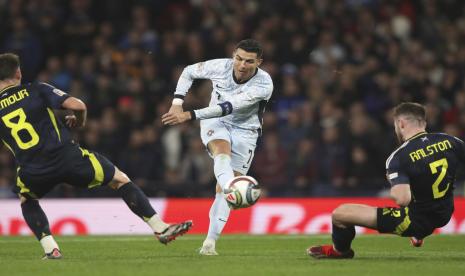 Pemain Portugal Cristiano Ronaldo, tengah, berusaha mencetak gol melewati pemain Skotlandia Anthony Ralston, kanan, selama pertandingan sepak bola UEFA Nations League antara Skotlandia dan Portugal di Hampden Park di Glasgow, Skotlandia, Rabu (16/10/2024) dini hari WIB.