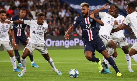 Pemain PSG Eric Maxim Choupo-Moting mencoba melewati pemain Toulouse dalam pertandingan Senin (26/8) dini hari