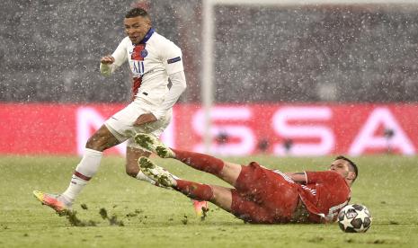 Pemain PSG Kylian Mbappe (kiri) dihadang pemain Bayern Muenchen Niklas Suele (kanan) pada pertandingan leg pertama perempat final Liga Champions di Allianz Arena, Kamis (8/4) dini hari WIB.