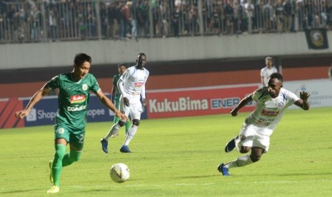 Pemain PSS Sleman, Purwaka Yudi dibayangi pemain Arema Riky Kayame pada pertandingan perdana Liga 1 di Stadion Maguwoharjo, Sleman, DIY, Rabu (15/5).