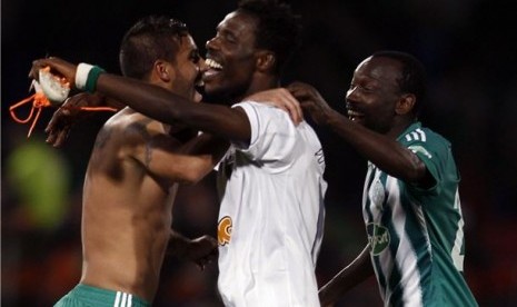 Pemain Raja Casblanca menari dengan jersey dan sepatu miliki Ronaldinho, pemain Atletico Mineiro, usai laga semifinal Piala Dunia Antarklub di Stadion Marrakech, Maroko, Rabu (18/12). 