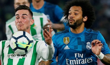 Pemain Real Betis, Fabian Ruiz (kiri), berebut bola dengan bek Real Madrid, Marcelo, pada laga La Liga di Benito Villamarin, Senin (19/2) dini hari WIB.