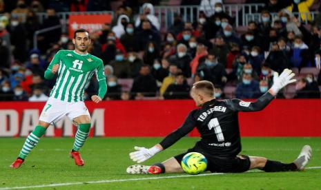 Pemain Real Betis Juanmi  (kiri) menjebol gawang Barcelona dalam pertandingan La Liga Spanyol di Camp Nou, Sabtu (4/12). Betis menang 1-0 dan menjadi kekalahan pertama Xavi Hernandez sebagai pelatih.