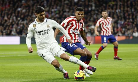 Pemain Real Madrid Asensio (kiri) beraksi melawan pemain Atletico Madrid Reinildo Mandava dalam pertandingan sepak bola LaLiga Spanyol antara Real Madrid dan Atletico Madrid, di Madrid,