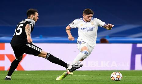 Pemain Real Madrid Federico Valverde, kanan, berduel memperebutkan bola dengan Gustavo Dulanto dari Sheriff pada pertandingan sepak bola grup D Liga Champions antara Real Madrid dan Sheriff, Tiraspol di stadion Bernabeu di Madrid, Spanyol, Rabu (29/9) di hari WIB.