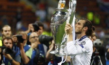 Gareth Bale mengecup trofi Liga Champions saat menjadi juara bersama Real Madrid beberapa waktu lalu.