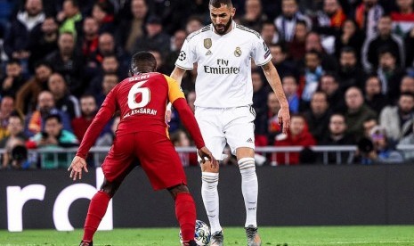 Pemain Real Madrid Karim Benzema berusaha melewati pemain Galatasary Jean Michel Serri dalam laga lanjutan Liga Champions