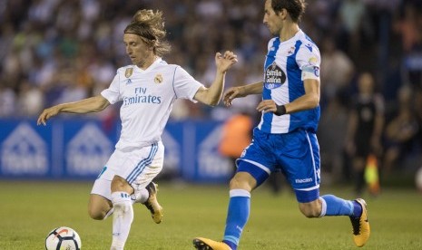 Pemain Real Madrid Luka Modric (kiri) bersama pemain Deportivo Mosquera di pertandingan La Liga Spanyol, Senin (21/8).