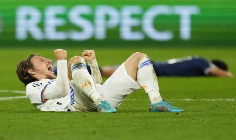 Gelandang Real Madrid Luka Modric merayakan kemenangan timnya saat pemain PSG yang dikalahkan berbaring di lapangan setelah pertandingan sepak bola leg kedua babak 16 besar Liga Champions antara Real Madrid dan Paris Saint-Germain (PSG) di Stadion Santiago Bernabeu di Madrid, Spanyol, Rabu, 9 Maret 2022 waktu setempat. 