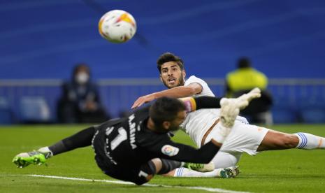 Pemain Real Madrid Marco Asensio menendang bola melewati kiper Mallorca Manolo Reina untuk mencetak gol ketiga timnya selama pertandingan sepak bola La Liga Spanyol antara Real Madrid dan Mallorca di stadion Bernabeu di Madrid, Spanyol, Rabu, 22 September 2021.