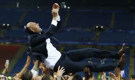 Pemain Real Madrid mengangkat pelatih Zinedine Zidane setelah mereka merayakan kemenangannya di Liga Champions, Ahad (29/5).