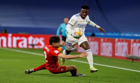 Pemain Real Madrid Vinicius Jr (kanan) berduel dengan penggawa Sevilla Gonzalo Montiel pada pertandingan La Liga 2021/2022 di Madrid, Senin (29/11).