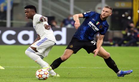 Pemain Real Madrid Vinicius Junior (kiri) berebut bola dengan pemain Inter Milan Skriniar pada pertandingan fase Grup D Liga Champions di Stadion Giuseppe Meazza, Milan, Italia, Kamis (16/9) WIB. 