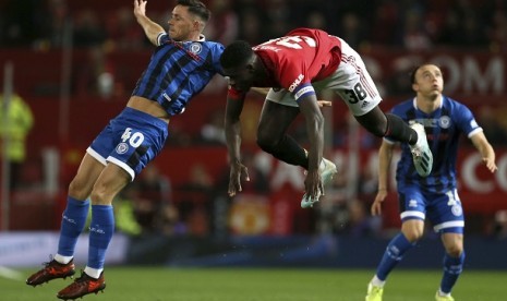 Pemain Rochdale Ian Henderson (kiri) bertarung memperebutkan bola dengan pemain Manchester United Axel Tuanzebe (kanan) dalam pertandingan putaran ketiga Piala Liga di Stadion Old Trafford, Kamis (26/9) dini hari WIB.