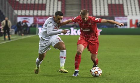 Pemain Salzburg, Noah Okafor (kiri) berebut bola dengan pemain Sevilla Ludwing Augustinsson (kanan) pada pertandingan Grup G Liga Champions di Stadion Red Bull Arena, Kamis (9/12).